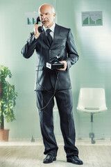 Senior businessman talking on a vintage telephone in the office