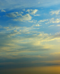 Sunrise sky with lighted clouds. Vertical photo.