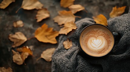 A cup of coffee with scattered autumn leaves, presenting a cozy, warm setup for fall-themed photography.