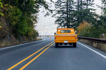 Classic pickup truck driving along road