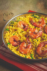 rice with saffron and shrimp, in a frying pan, paella with shrimp, top view, homemade, no people,