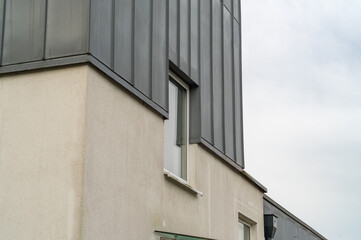 Modern building facade featuring contrasting textures and a single window