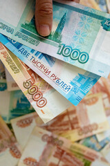 Funds of the Russian Federation. Russian rubles in a woman's hand. Financial concept. The background and texture of banknotes. Banknotes in denominations of 5000, 2000 and 1000 rubles. Vertical