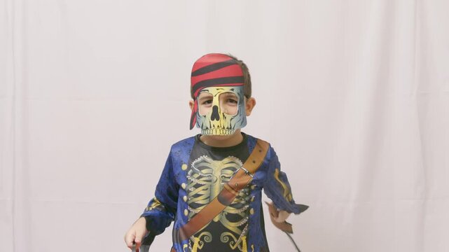 Halloween costume. Child with a skeleton pirate costume slicing air with sword. High quality 4k footage