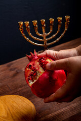 challah, honey, apple and pomegranate and burning candles on the table Shabbat Rosh Hashanah