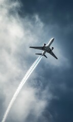 Airplane flying through cloudy sky with contrail.