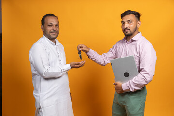 Indian Sales person Giving Vehicle key to Farmer after loan sanction , Young Indian banker giving a...