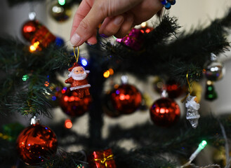 Families decorating New Year trees in their homes before Christmas