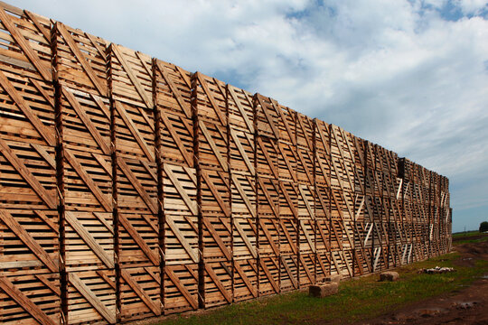 Rows of wooden crates, crates and pallets for storing and transporting fruits and vegetables in the warehouse. Production warehouse on territory of agro-industrial complex.