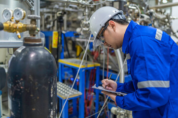 Asian engineer working at Operating hall,Thailand people wear helmet  work,He worked with diligence and patience,she checked the valve regulator at the hydrogen tank.