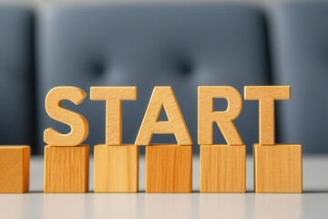 Wooden blocks spelling the word START on a table with a blurred background.