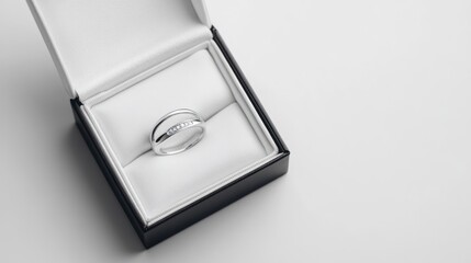 A silver ring displayed in an elegant jewelry box, symbolizing love and commitment.