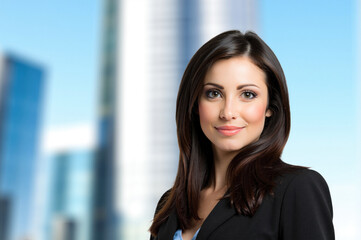 Fototapeta premium Confident businesswoman smiling with city skyline background