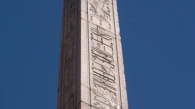 Piazza Navona, Fontana dei Quattro Fiumi: zoom out da geroglifici egizi dell'obelisco, su cielo azzurro, fino alla punta