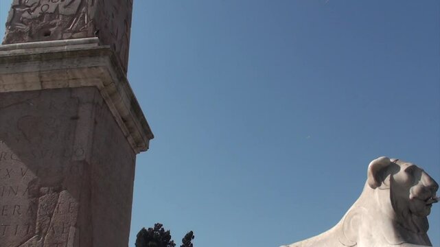 Fontana dei Leoni, Piazza del Popolo: camera sale dall'acqua verso l'obelisco, raggiungendo la sommit&agrave; in un movimento fluido verso l'alto