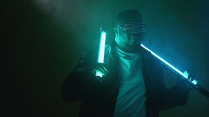 Rapper performance. Nightclub show. Confident brutal stylish hip hop musician man artist with bright neon lamp lights at night event on smoke background copy space.