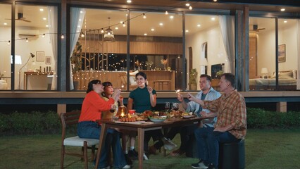 Happy family holding glowed sparkler in holiday celebration party at night. Lovely member enjoy...