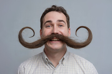 Cheerful man with a huge mustache on a light background.