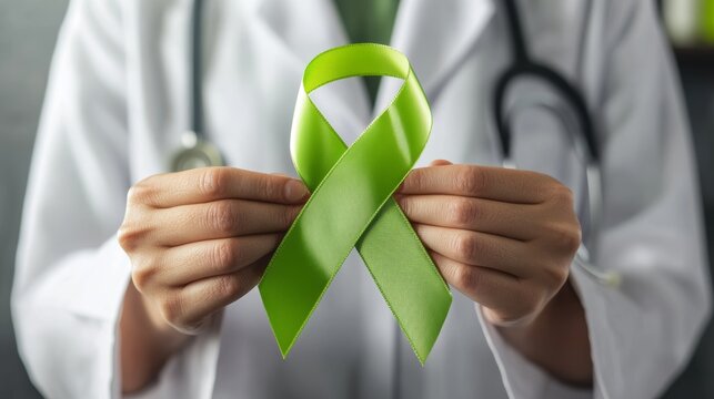 A doctor holds a lime green ribbon, symbolizing support for Lymphoma, mental health awareness, Lyme Disease, and spinal cord injuries. 