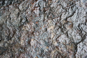 Wet rock background. Grunge texture of shiny stone. Steel like appearance. Scratched and rough surface. Industrial black background. Dark stone backdrop. Rock texture.