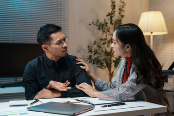 Businesswoman comforting her stressed colleague while working late in the office