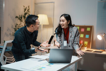 Two business colleagues having a disagreement at work while looking at each other in the office at night