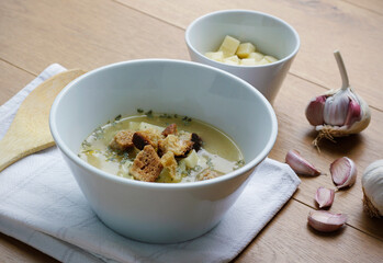 Bowl of a traditional Czech and Slovak garlic soup (called cesnecka or oukrop) cooked from broth, garlic, potatoes, cumin and egg and served with cheese and croutons. Traditional Czech, Slovak dish.