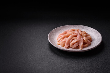 Raw chicken fillet cut into strips with spices and herbs