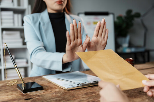 Businesswoman is refusing to receive money in brown envelope, corruption concept