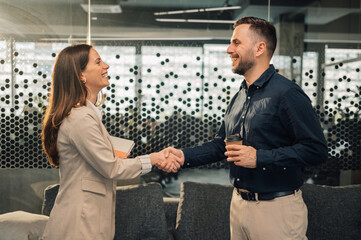 Side view of businesswoman shaking hands with friendly chief.