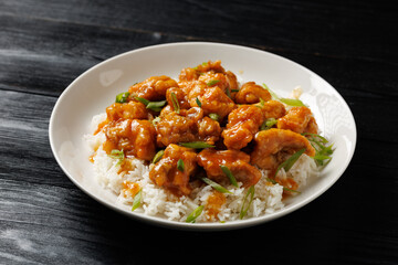 Chinese orange chicken with rice and green onion garnish