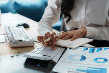Businesswoman is calculating tax using a calculator for finances at her office desk