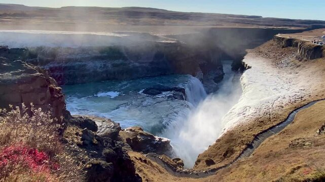 Gullfoss waterfall flows powerfully in Iceland beneath a radiant sunny sky, highlighting the breathtaking beauty of nature