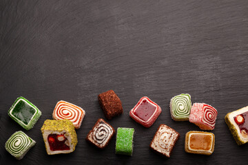 Assortment of Turkish sweets with nuts on a black background. A scattering of Turkish delight