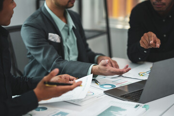 Businesspeople analyzing financial data on laptop computer, working with graphs, brainstorming new business ideas