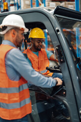 Warehouse manager explaining to driver using digital tablet while sitting on forklift in a warehouse © Zamrznuti tonovi