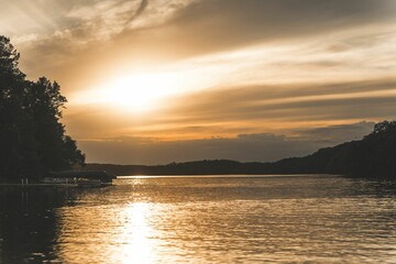 Mesmerizing sunset view of Mound Lake with greenery trees in Minnesota in the summer with cloudy sky