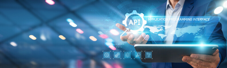 API. Businessman using tablet analyzing API integration with various software systems, data exchange protocols, real-time performance metrics, user engagement trends, market competition analytics.