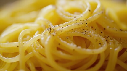 A close-up of spaghetti topped with black pepper, showcasing its texture and simplicity.