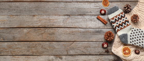 Beautiful composition with warm socks and sweater on wooden background
