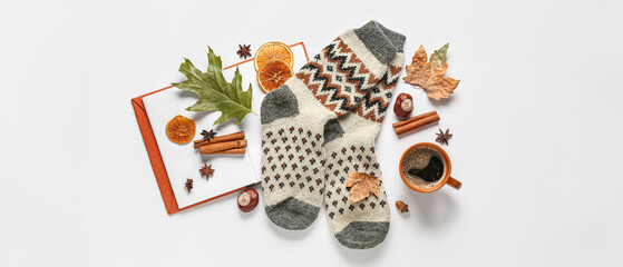 Beautiful composition with warm socks, book and cup of coffee on white background