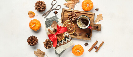 Composition with warm socks and mug of coffee on white background