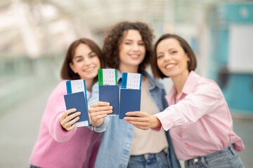 Three friends happily showcase their passports and travel tickets at the airport, excited for their upcoming adventure together. The atmosphere is filled with anticipation and joy.