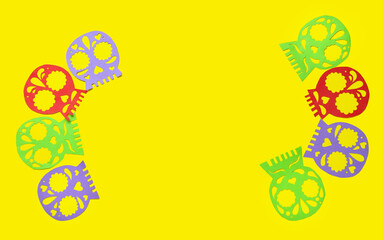 Colorful paper skulls on yellow background. Celebration of Mexico's Day of the Dead (El Dia de Muertos)