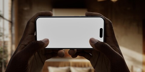 Caucasian White middle aged male using smartphone with a blank white screen. Bedroom, bed, window apps mockup. Horizontal phone orientation