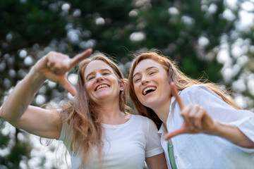 Joyful moments captured in the park as two friends share laughter and creativity during a sunny afternoon