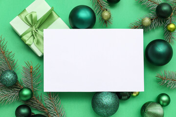 Blank card, Christmas balls, gift box and fir branches on green background