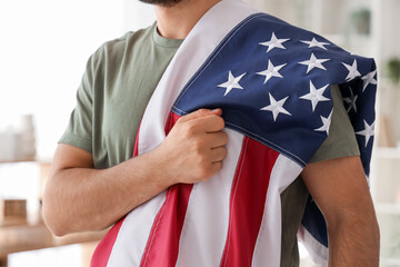 Young soldier with USA flag praying at home, closeup. Veterans Day celebration