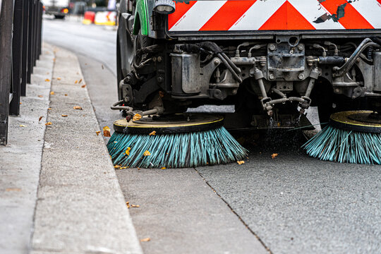 Fototapeta Paris, France - 15 September 2022: Street cleaning machine gathers trash, garbage and leaves