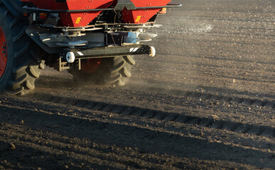 Farmer fertilizing arable land with nitrogen fertilizer